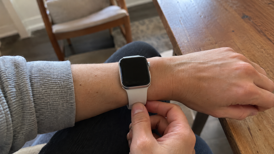 Apple Watch met wit bandje strak om de pols gedragen